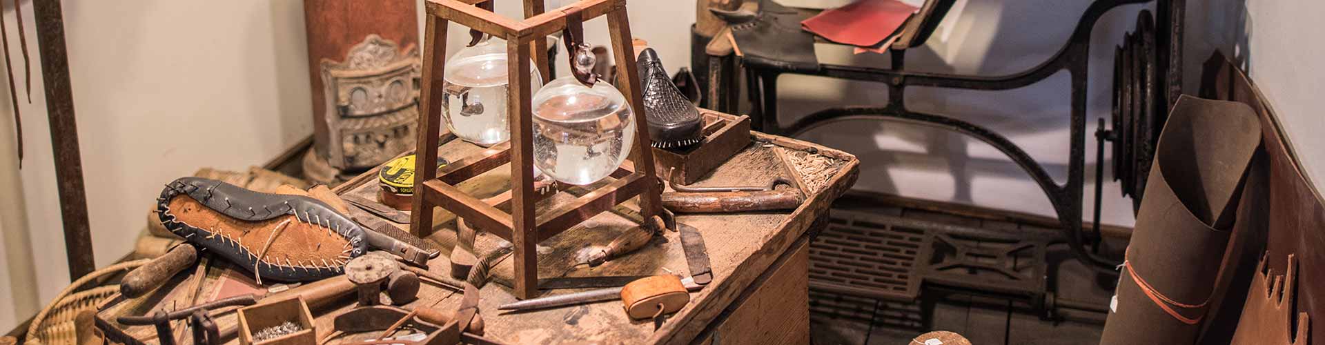 Historische Schusterwerkstatt mit Schusterkugeln, Werkzeug und Leder
